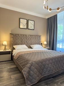 une chambre avec un grand lit et deux lampes dans l'établissement Апартаменти SeaGems, à Karolino-Buhaz