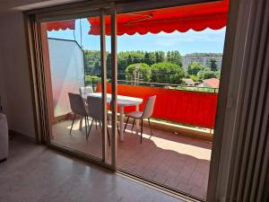 a room with a balcony with a table and chairs at Appartement exposé plein sud in Menton +8 photos