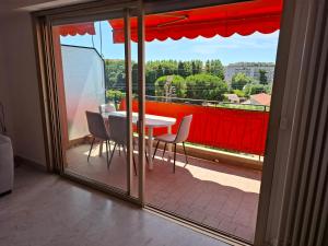 a room with a table and chairs on a balcony at Appartement exposé plein sud in Menton