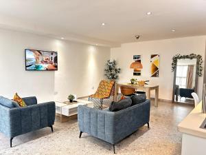 a living room with two couches and a table at Urban One Luxury Apartments, Kumasi - Gye Nyame in Kumasi