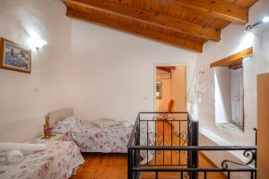una camera con due letti e una scala in una stanza di Villa Sofita with jacuzzi a Maroulás
