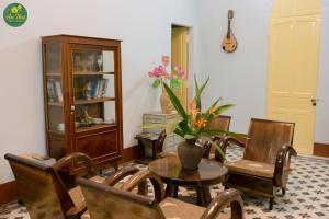 - un salon avec une table, des chaises et une guitare dans l'établissement An Thư Home Garden, à Hue