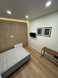 a bedroom with a bed and a table at 12 New Airport Apartment in Pakopi
