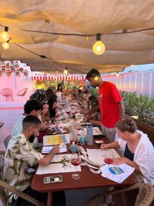 un grupo de personas sentadas en una mesa larga en The Loft House Sevilla, en Sevilla