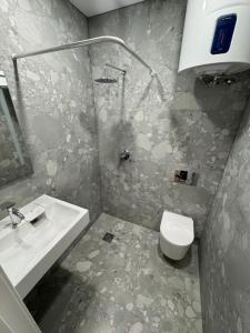 a bathroom with a toilet and a sink at 12 New Airport Apartment in Pakopi