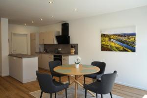 a kitchen and dining room with a table and chairs at Hain Estate Appartements in Piesport