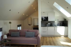 Una sala de estar con un sofá y una cocina. en Hain Estate Appartements, en Piesport 8 fotos más