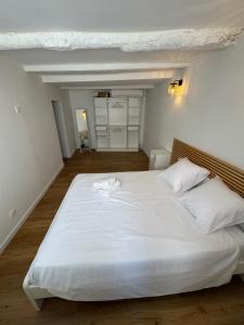 a large white bed with two white towels on it at Marceau II - Une pépite dans le cœur de ville in Aubagne