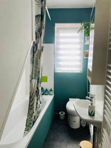 ein blaues Badezimmer mit Toilette und Waschbecken in der Unterkunft L'écorce marine in Sangatte