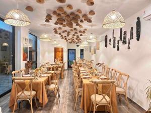 a dining room with long tables and chairs and chandeliers at Urban One Luxury Apartments, Kumasi - Gye Nyame in Kumasi