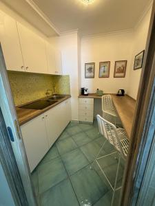 a kitchen with white cabinets and green tile floors at Casa Adelaide in Capri
