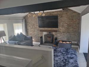 a living room with a couch and a fireplace at Alocin cottage in Melmerby