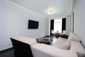 a white living room with a couch and a table at Жулдыз рядом с Аэропортом in Almaty