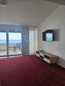 a living room with a television and a table with a view at Beach Villa Bozikovic in Podstrana