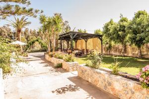 um gazebo num jardim com árvores e flores em Grameno Apartments em Kountoura Selino