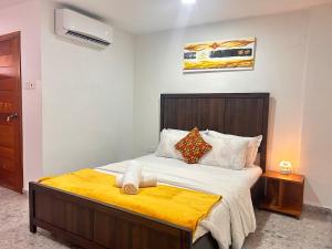 a bedroom with a large bed with a yellow blanket at Urban One Luxury Apartments, Kumasi - Gye Nyame in Kumasi