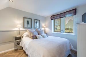 a bedroom with a white bed with a window at Beech Meadow-Home from Home Luxury Holiday Cottage in Kirkby Lonsdale