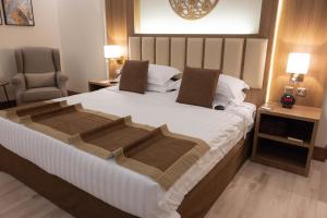 a bedroom with a large bed and a chair at Sakura City Hotel in Al Baha