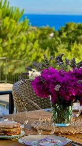 a table with purple flowers in a vase on it at Most Oliva Resort Budva in Budva