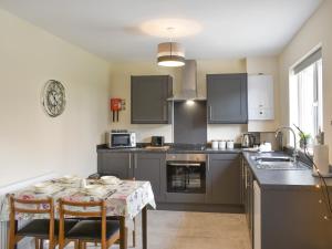 a kitchen with a table with chairs and a sink at Two Dorchester Drive - Uk32036 in Inglewhite