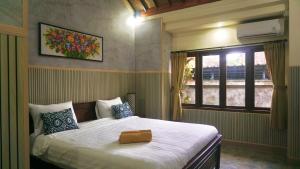 a bedroom with a large bed and a window at Utu Homestay in Ubud