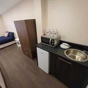 a small kitchen with a sink and a microwave at 95 Deluxe London Studios in London +10 photos