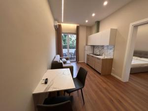 a room with a table and chairs and a bedroom at Molla Apartments Golem in Polisi i Vogël