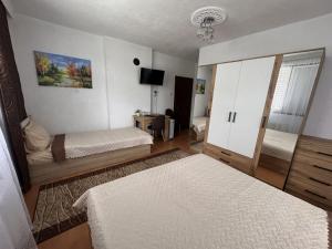 a small bedroom with two beds and a mirror at Къща за гости Здравец  in Trigrad