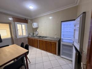 a kitchen with a refrigerator and a table in it at Home Together Family in Tetouan