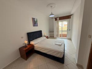 a bedroom with a bed and a table and a window at Home Together Family in Tetouan
