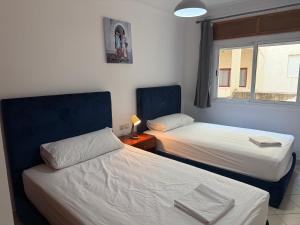 a bedroom with two beds and a window with at Home Together Family in Tetouan