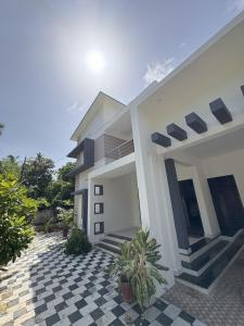 a white house with a black and white checkered floor at Tattwamasi Annex with Breakfast and Yoga in Varkala