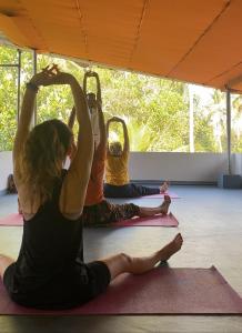 a group of people sitting on mats in a yoga class at Tattwamasi Annex with Breakfast and Yoga in Varkala +9 photos