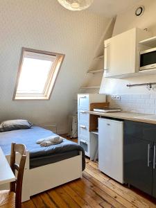 Cet appartement comprend une chambre avec un lit et une cuisine avec une fenêtre. dans l'établissement Superbe studio a 5min des Champs-Élysées, à Paris