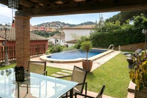 a patio with a table and chairs and a swimming pool at 3 bedroom villa close to the center with private pool & garden H30 in Begur