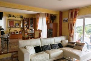a living room with a white couch and a kitchen at 3 bedroom villa close to the center with private pool & garden H30 in Begur