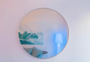 a round mirror on a wall with a blue wall at Rosalù - Sea View in Polignano a Mare +12 photos