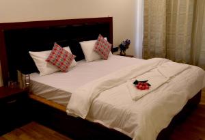 a large bed with white sheets and pillows on it at Tsanavilla guest house in ladakh
