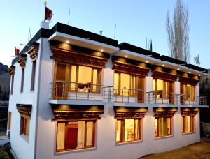 a large white building with a balcony on it at Tsanavilla guest house in ladakh