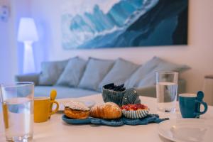 a table with cups and plates of pastries on it at Rosalù - Sea View in Polignano a Mare
