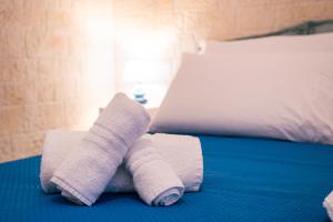 a pile of towels sitting on top of a bed at Rosalù - Sea View in Polignano a Mare