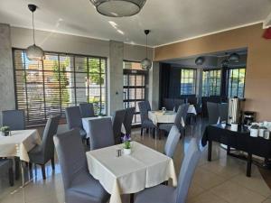 a dining room with white tables and chairs and tablesearcher at Eurybia in Łeba