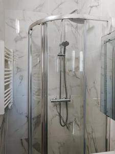 a shower in a bathroom with white marble at Quiet and bright apartment with separate bedroom in Nice