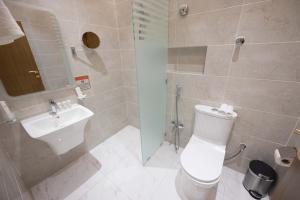 a bathroom with a toilet and a sink at Sakura City Hotel in Al Baha