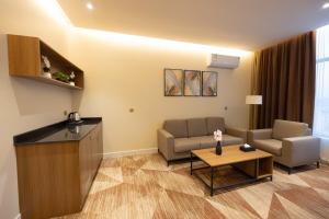 a living room with two chairs and a couch and a table at Sakura City Hotel in Al Baha +36 photos