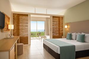 a hotel room with a large bed and a balcony at The Freij Resort in Ayia Napa +36 photos
