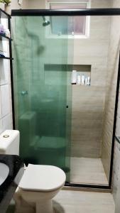 a bathroom with a toilet and a glass shower at Residencial Privê Sol Tropical in Belém