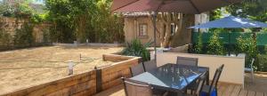 a patio with a table and an umbrella at Grande OU petite maison sur 360m2 de jardin clos sans vis à vis in Gentilly