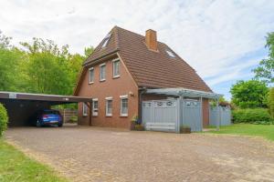 a brick house with a garage and a car at Achtern Diek 28A in Otterndorf