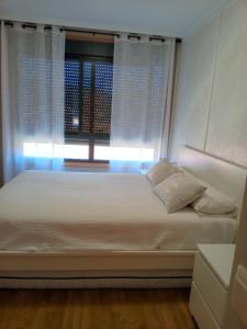 una cama en una habitación con ventana en apartamento vilariño, en Cangas de Morrazo